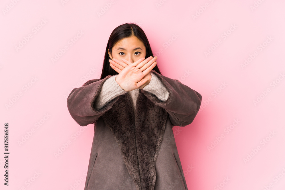 Young chinese woman wearing a coat isolated doing a denial gesture Young chinese woman wearing a coat isolated doing a denial gesture