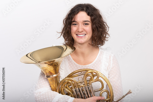 Porträt einer jungen Hornistin eines Philharmonischen Orchesters mit ihrem Instrument photo