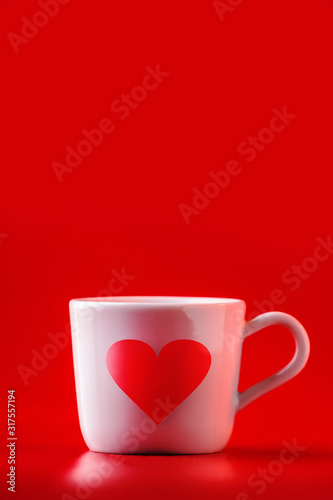 Valentine's day celebration or love template. Cup of tea or coffee with heart on red background. Copy space