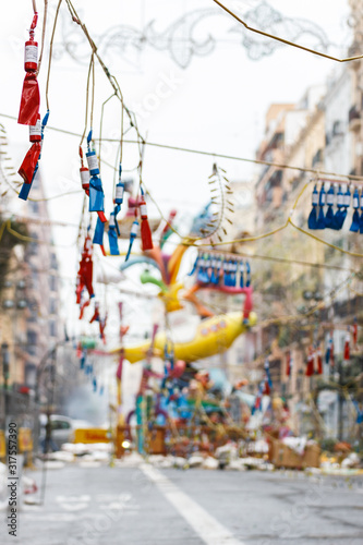 Festival of the Fallas in Valencia. Firecrackers and sculpture of the fallas festival in Valencia in the background. 