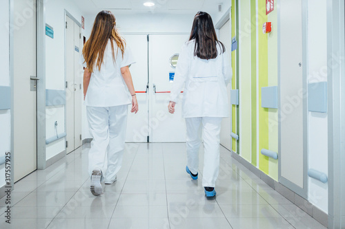 Nurse and doctor walking along the corridor of the hospital -