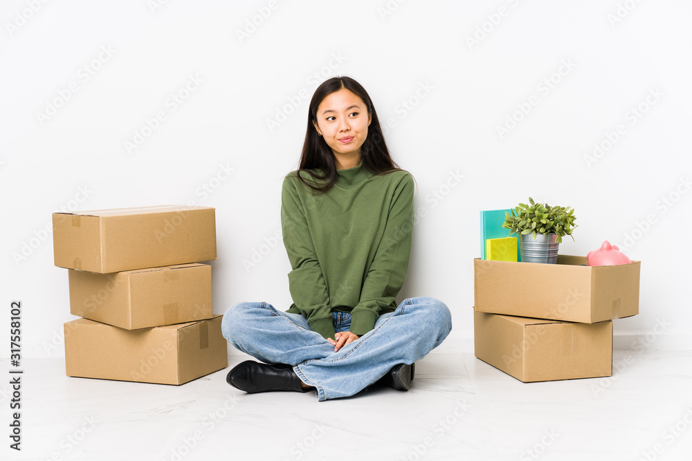 Young chinese woman moving to a new home dreaming of achieving goals and purposes Young chinese woman moving to a new home dreaming of achieving goals and purposes