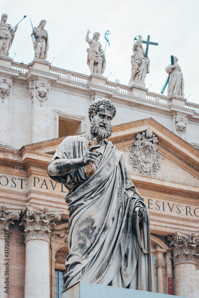 Statue of St. Peter in the Vatican, in the background of St. Peter's Basilica.