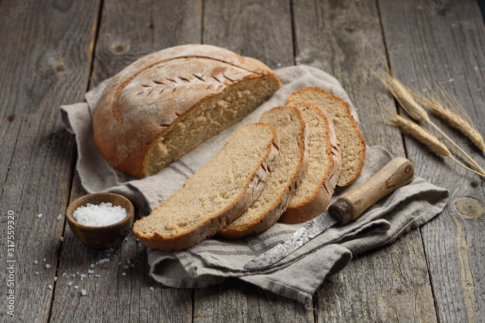 Homemade wheat rye bread on a wooden background. Sliced loaf of bread. Selective focus Homemade wheat rye bread on a wooden background. Sliced loaf of bread. Selective focus