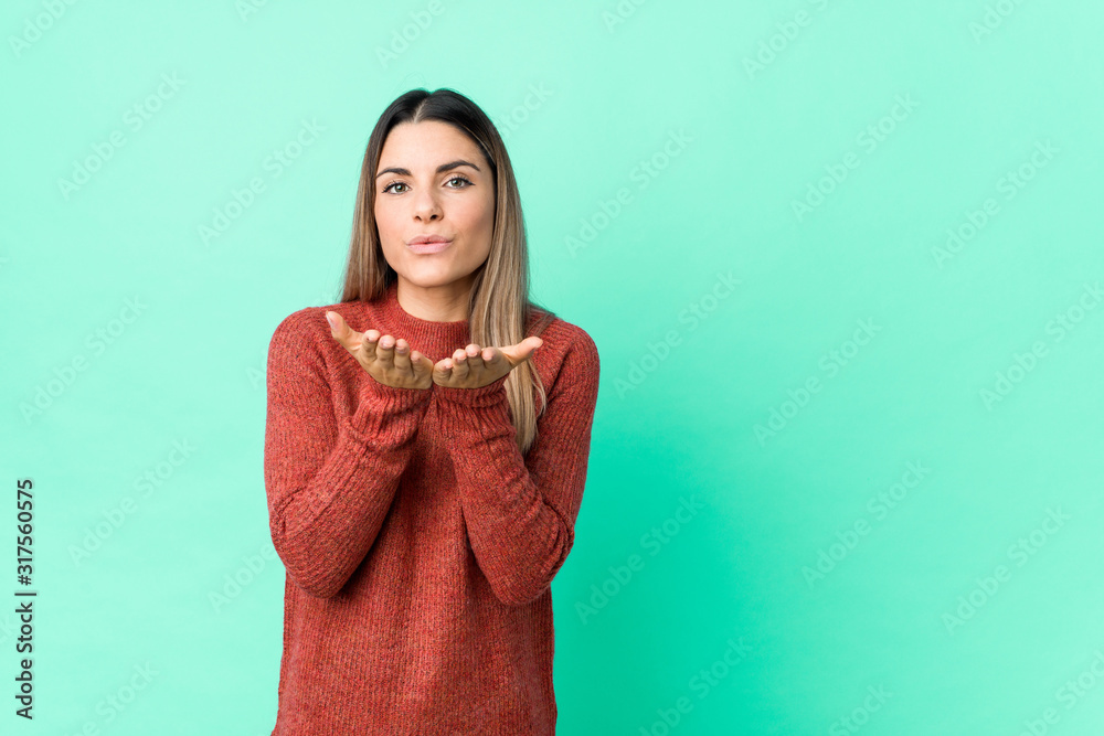 Young caucasian woman isolated folding lips and holding palms to send air kiss. Young caucasian woman isolated folding lips and holding palms to send air kiss.