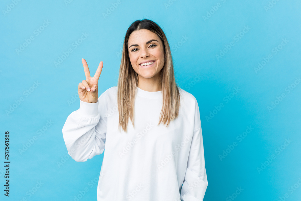 Young caucasian woman isolated showing victory sign and smiling broadly. Young caucasian woman isolated showing victory sign and smiling broadly.