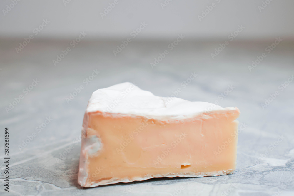 Camembert cheese on a table with vegetables