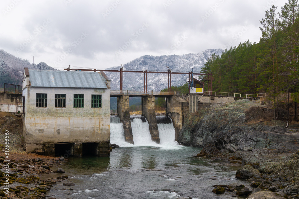 abandoned hydroelectric power station on a background of mountains