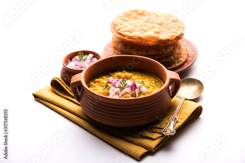 Dal pakwan is an authentic Sindhi breakfast. It is a combination of deepfried, crisp and unpuffed Maida puris served with Daal made using chana or split chickpea. selective focus photo