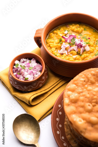 Dal pakwan is an authentic Sindhi breakfast. It is a combination of deepfried, crisp and unpuffed Maida puris served with Daal made using chana or split chickpea. selective focus