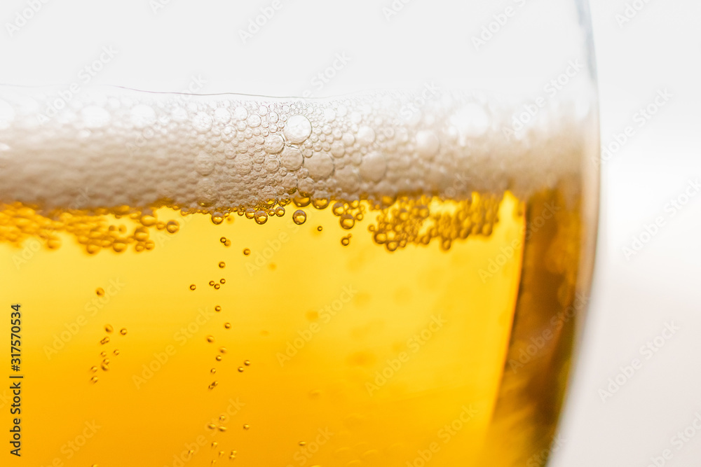 Light beer in a glass, macro photo. Above is foam. Abstract background image of a drink. Light beer in a glass, macro photo. Above is foam. Abstract background image of a drink.