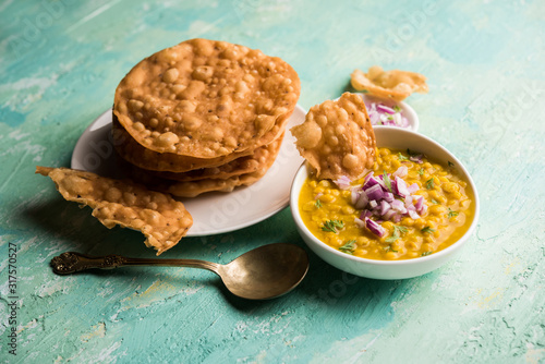 Dal pakwan is an authentic Sindhi breakfast. It is a combination of deepfried, crisp and unpuffed Maida puris served with Daal made using chana or split chickpea. selective focus photo