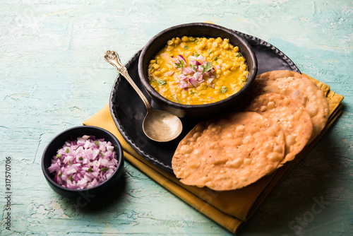 Dal pakwan is an authentic Sindhi breakfast. It is a combination of deepfried, crisp and unpuffed Maida puris served with Daal made using chana or split chickpea. selective focus