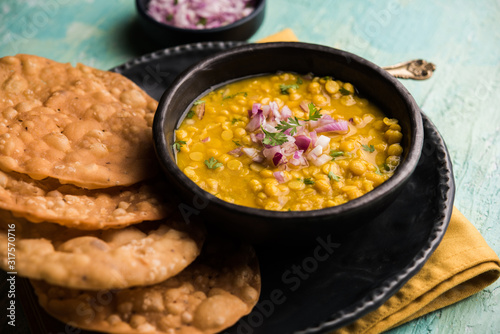 Dal pakwan is an authentic Sindhi breakfast. It is a combination of deepfried, crisp and unpuffed Maida puris served with Daal made using chana or split chickpea. selective focus