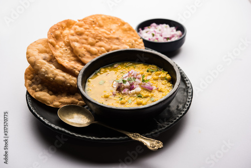 Dal pakwan is an authentic Sindhi breakfast. It is a combination of deepfried, crisp and unpuffed Maida puris served with Daal made using chana or split chickpea. selective focus photo