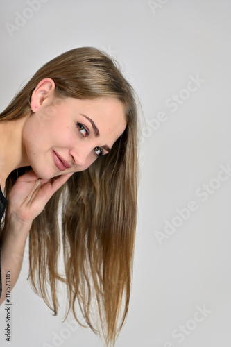 Generic female portrait concept for cosmetics advertising on a white background. A large photo of a pretty smiling girl with long hair and excellent make-up is standing in different poses.