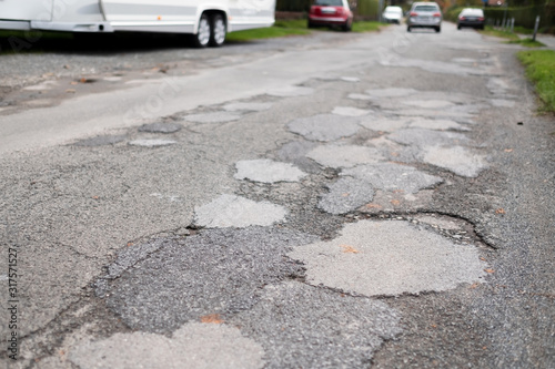 Fototapeta Naklejka Na Ścianę i Meble -  Holes and damaged road in small town of Germany, Europe