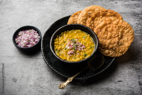 Dal pakwan is an authentic Sindhi breakfast. It is a combination of deepfried, crisp and unpuffed Maida puris served with Daal made using chana or split chickpea. selective focus photo