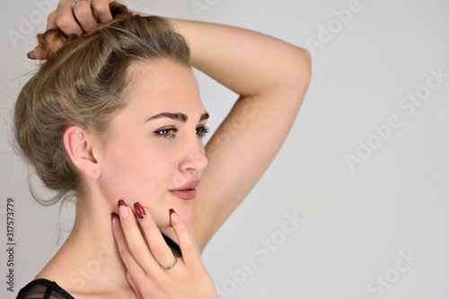 Generic female portrait concept for cosmetics advertising on a white background. A large photo of a pretty smiling girl with long hair and excellent make-up is standing in different poses.