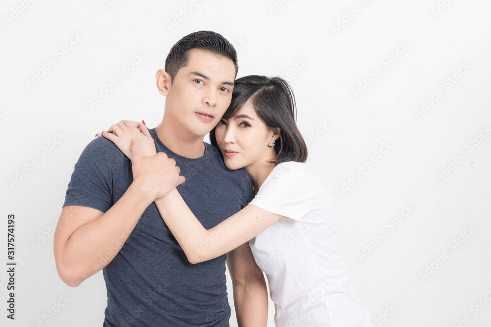 Portrait of happy young couple embracing in studio shot on white background. Portrait of happy young couple embracing in studio shot on white background.