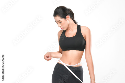 Shapely woman long hair wearing black fitness clothes in a series of exercises now measure around her waist isolated on white background. © Look Aod 27