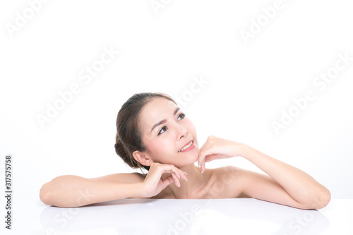 Charming young asian woman with clean fresh skin  Hair sleek  Proposing a product while lying on isolated on white background  Front view  copy space on the top.