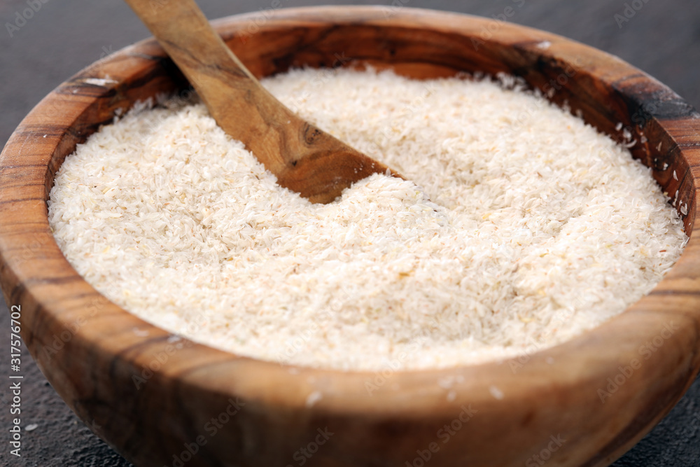 Portion of Psyllium Seeds on rustic dark background. Psyllium seed husks on wood Portion of Psyllium Seeds on rustic dark background. Psyllium seed husks on wood