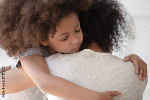 Canvastavla African daughter hugs mother rear back closeup view