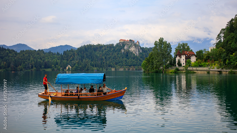Bled / Slovenia - August 2019: tourists in Pletna boat at lake