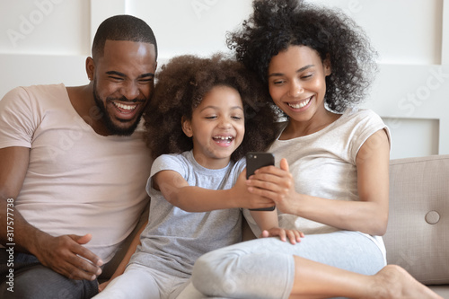 Full african family enjoy free time together using smartphone