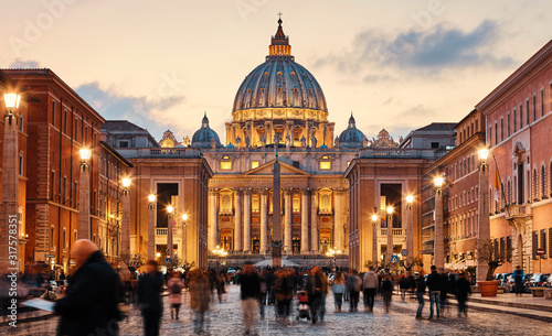 Vatican City Holy( See). Rome, Italy. Dome of St. Peters Basil cathedral at Saint Peters Square. Evening sunset, golden hour with evening sky and street lamps. © Yasonya