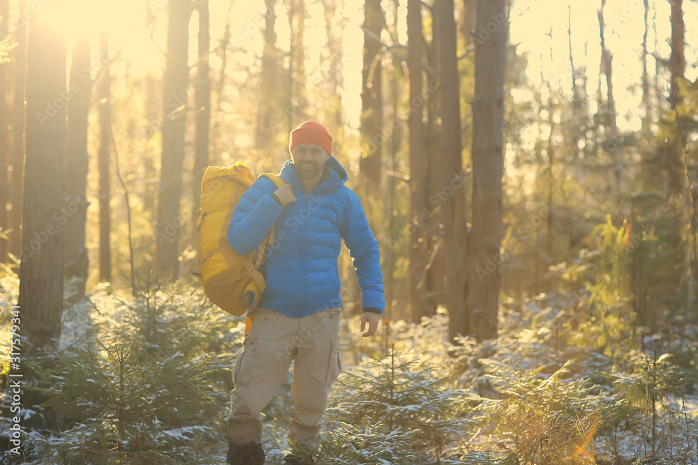 winter landscape forest backpack man / traveler in modern winter clothes in the forest, traveling in the mountains  europe, switzerland winter