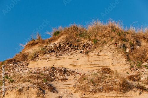 Détritus enfouis dans les dunes