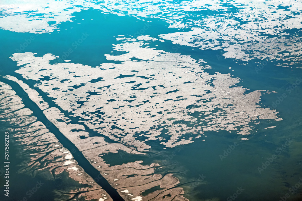 delta of volga river water joint to caspian sea landscape aerial top down drone wide view against winter nature background. Earth surface satellite imagery. Natural color of caspian coastal scenery
