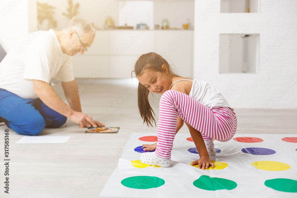 little girl and grandfather play twister at home Stock Photo | Adobe Stock