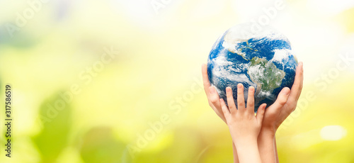Fototapeta Naklejka Na Ścianę i Meble -  Earth globe in family hands. World environment day. Elements of this image furnished by NASA.