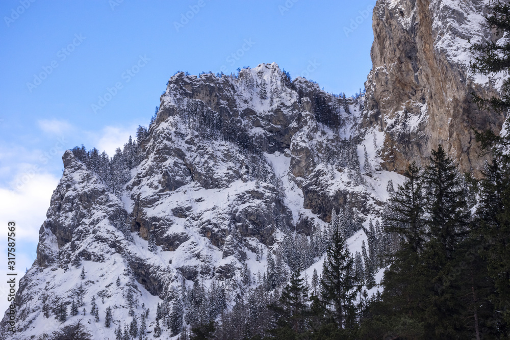Detail of mountain face with rocks, snow and trees near Green lake (Grunner see) in sunny winter day. Famous tourist destination for walking and trekking in Styria region, Austria