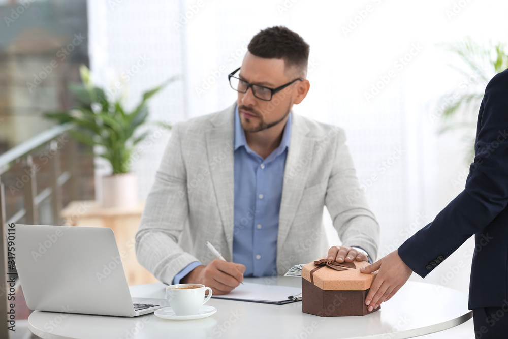 Woman giving bribe to man at table indoors