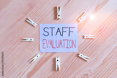 Handwriting text Staff Evaluation. Conceptual photo assessment and review of a worker s is job perforanalysisce Colored clothespin papers empty reminder wooden floor background office photo