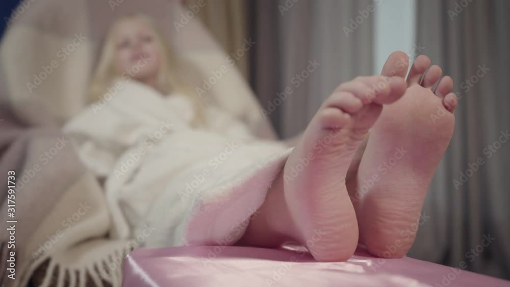 Little blond Caucasian girl in white bathrobe sitting on ...