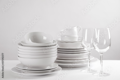 Set of clean dishes on white table photo