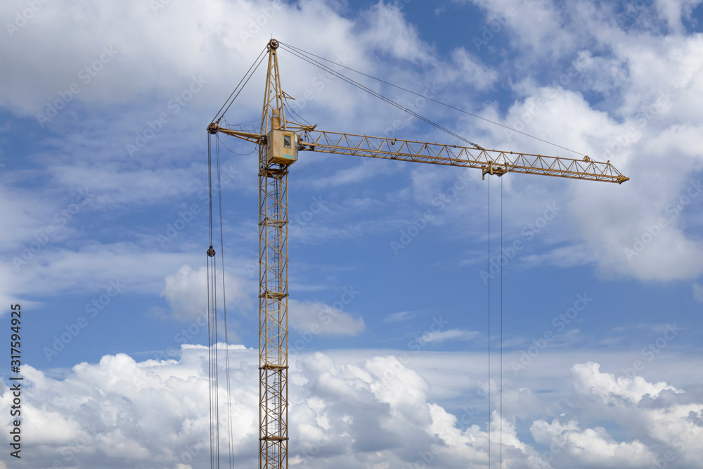 Tower Crane in the clouds and blue sky.