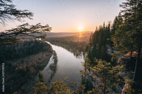 Beautiful morning landscape, first sun rays appears over mountains and river valley, Usva, Ural mountains.