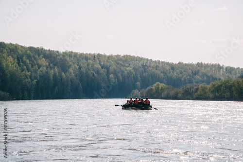 Team of people float down the River on inflatable catamaran