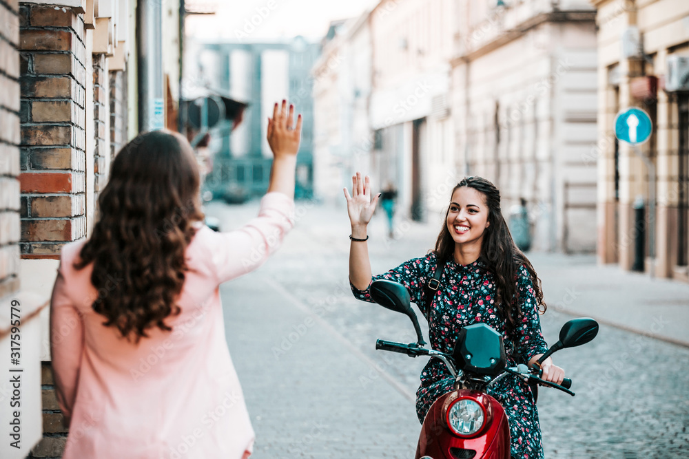 Obraz premium Two happy friends meeting and greeting in the street