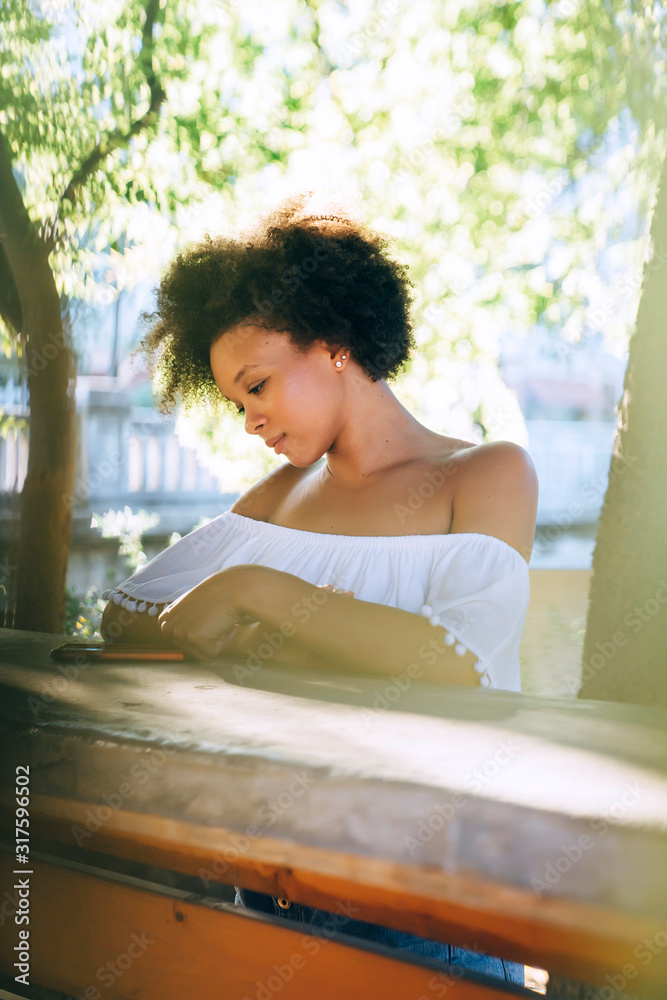 Woman in white off the shoulder top messaging on cell phone Woman in white off the shoulder top messaging on cell phone