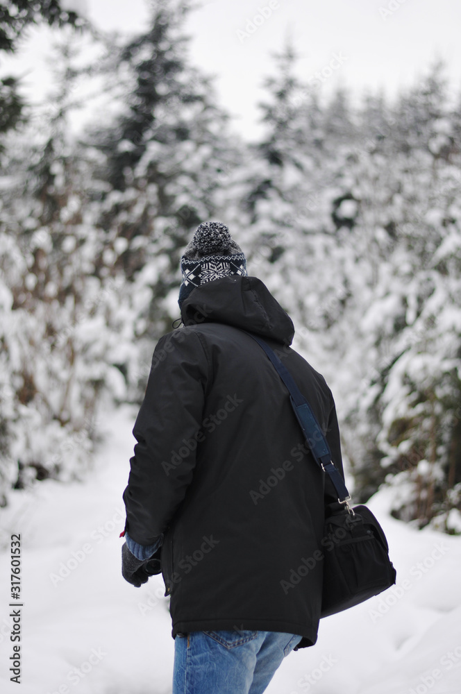 Traveler Man  in winter snowy forest landscape Travel Lifestyle concept adventure active vacations outdoor cold weather into the wild