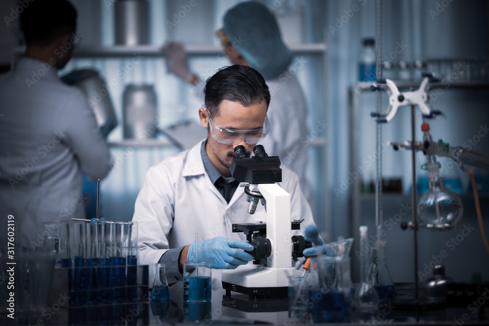 Young scientist working with a microscope in a laboratory. Young scientist doing some research. Young scientist working with a microscope in a laboratory. Young scientist doing some research.