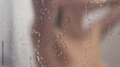 Blurred silhouette of a woman taking a shower