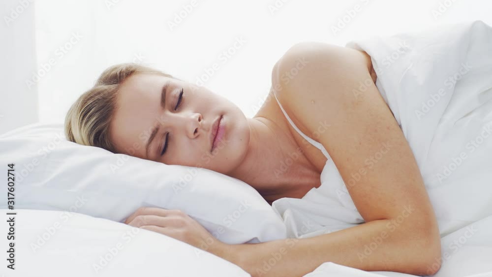 Young woman lying in the bed. Beautiful blond sleeping girl. Morning in the bedroom. Health and rest concept. Young woman lying in the bed. Beautiful blond sleeping girl. Morning in the bedroom. Health and rest concept.